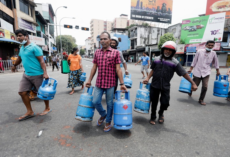 SRI LANKA-CRISIS/ People block a main road as they wait for the gas trucks to arrive at the station to distribute for them, amid the country's economic crisis in Colombo, Sri Lanka, May 8, 2022. REUTERS/Dinuka Liyanawatte