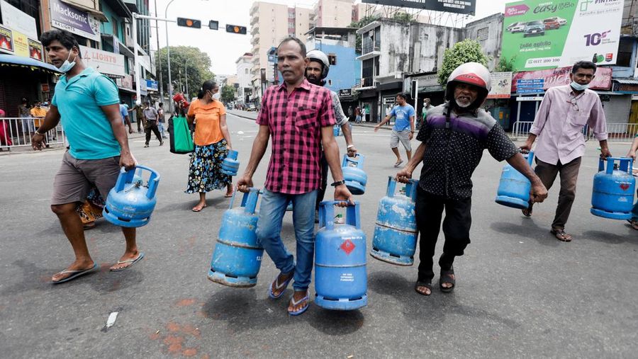 People block a main road as they wait for the gas trucks to arrive at the station to distribute for them, amid the country's economic crisis in Colombo, Sri Lanka, May 8, 2022. REUTERS/Dinuka Liyanawatte
