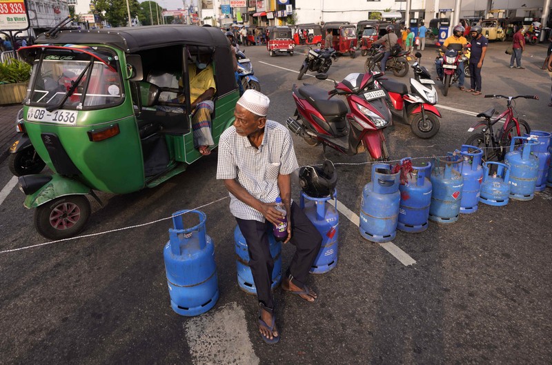 SRI LANKA-CRISIS/ People block a main road as they wait for the gas trucks to arrive at the station to distribute for them, amid the country's economic crisis in Colombo, Sri Lanka, May 8, 2022. REUTERS/Dinuka Liyanawatte