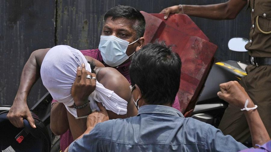 Sri Lanka's pro government and anti government protestors clash as police fires water canons outside the president's office in Colombo, Sri Lanka, Monday, May 9, 2022. Government supporters on Monday attacked protesters who have been camped outside the office of Sri Lanka's prime minster, as trade unions began a 
