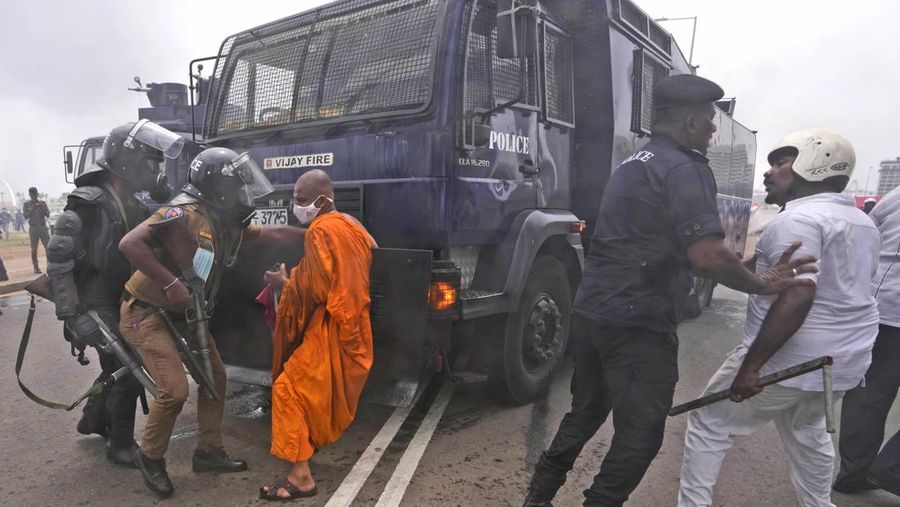 Sri Lanka's pro government and anti government protestors clash as police fires water canons outside the president's office in Colombo, Sri Lanka, Monday, May 9, 2022. Government supporters on Monday attacked protesters who have been camped outside the office of Sri Lanka's prime minster, as trade unions began a 