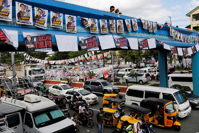 Staff members sit at computers as screens show an official quick-count of the national election at a command center of the Parish Pastoral Council for Responsible Voting (PPCRV), the election watchdog organization in Manila, Philippines, May 9, 2022. REUTERS/Willy Kurniawan