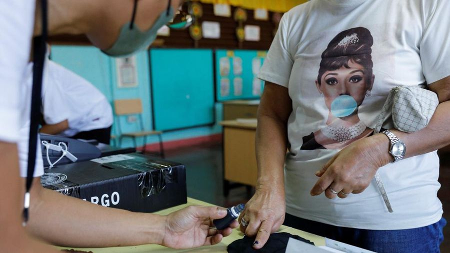A voter has her finger inked after casting her ballot at a polling precinct during the national elections in Manila, Philippines, May 9, 2022. REUTERS/Willy Kurniawan