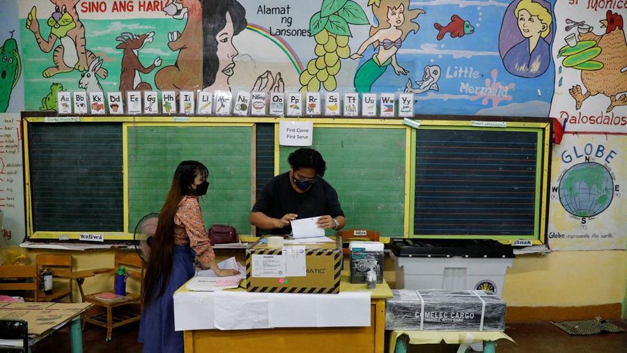 Staff members sit at computers as screens show an official quick-count of the national election at a command center of the Parish Pastoral Council for Responsible Voting (PPCRV), the election watchdog organization in Manila, Philippines, May 9, 2022. REUTERS/Willy Kurniawan