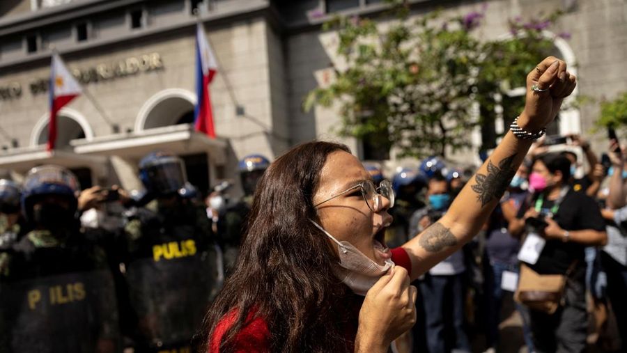 Students and activists march outside the Commission on Elections to protest its unofficial tally of the national elections, showing presidential candidate Ferdinand 