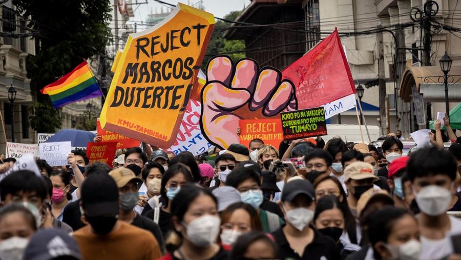 Students and activists march outside the Commission on Elections to protest its unofficial tally of the national elections, showing presidential candidate Ferdinand 
