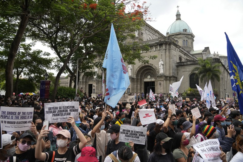 Students and activists march outside the Commission on Elections to protest its unofficial tally of the national elections, showing presidential candidate Ferdinand 