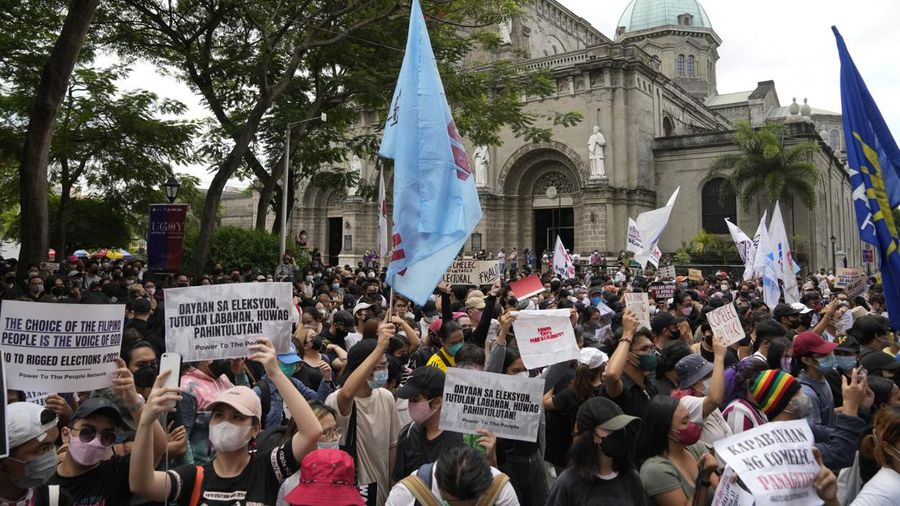 Students and activists march outside the Commission on Elections to protest its unofficial tally of the national elections, showing presidential candidate Ferdinand 
