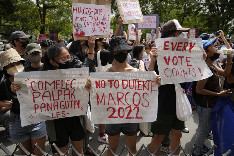 Students and activists march outside the Commission on Elections to protest its unofficial tally of the national elections, showing presidential candidate Ferdinand 
