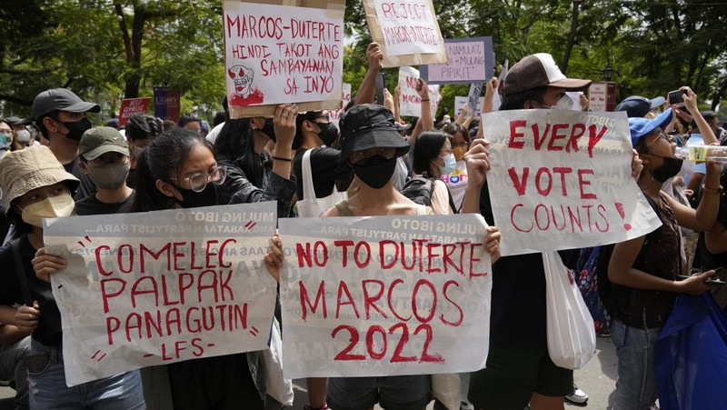 Students and activists march outside the Commission on Elections to protest its unofficial tally of the national elections, showing presidential candidate Ferdinand 