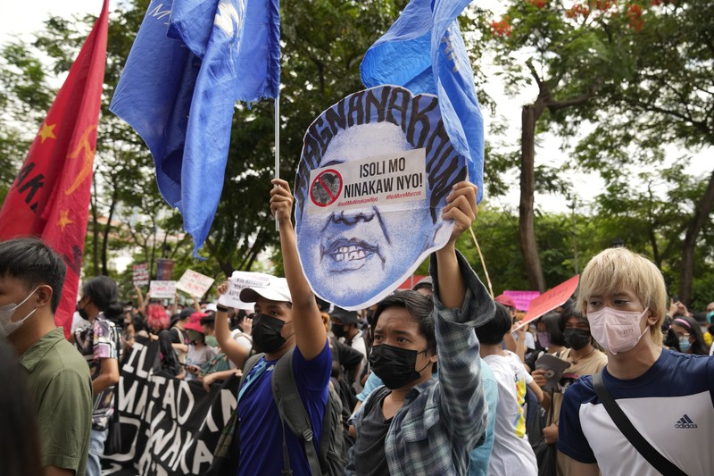 Students and activists march outside the Commission on Elections to protest its unofficial tally of the national elections, showing presidential candidate Ferdinand 