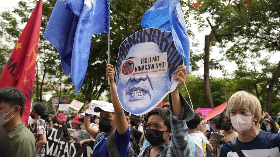 Students and activists march outside the Commission on Elections to protest its unofficial tally of the national elections, showing presidential candidate Ferdinand 