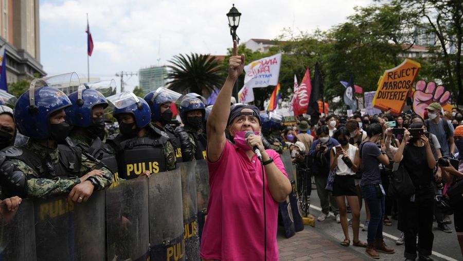 Students and activists march outside the Commission on Elections to protest its unofficial tally of the national elections, showing presidential candidate Ferdinand 