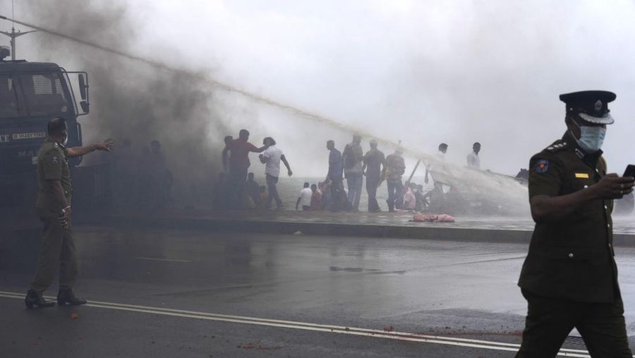 Sri Lanka's pro government and anti government protestors clash as police fires water canons outside the president's office in Colombo, Sri Lanka, Monday, May 9, 2022. Government supporters on Monday attacked protesters who have been camped outside the office of Sri Lanka's prime minster, as trade unions began a 