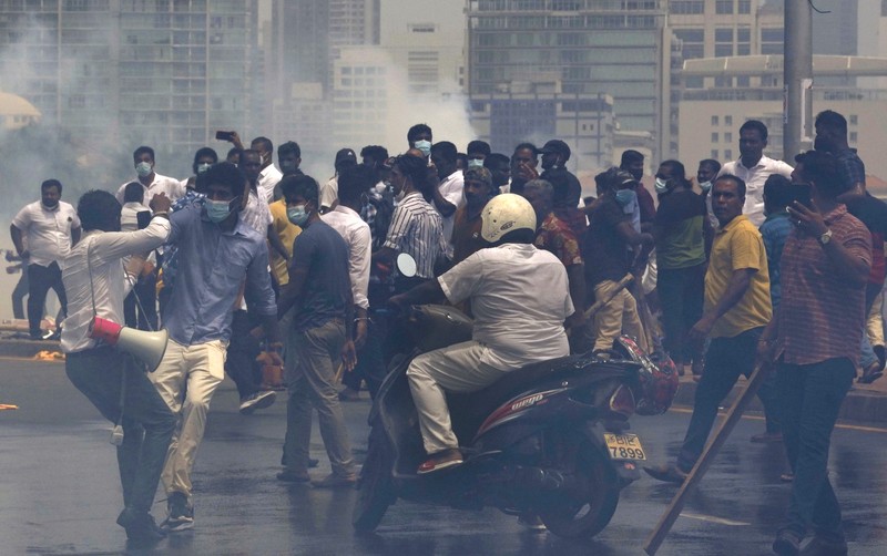 Sri Lanka's pro government and anti government protestors clash as police fires water canons outside the president's office in Colombo, Sri Lanka, Monday, May 9, 2022. Government supporters on Monday attacked protesters who have been camped outside the office of Sri Lanka's prime minster, as trade unions began a 