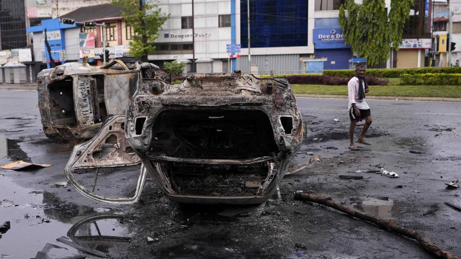 Sri Lanka's pro government and anti government protestors clash as police fires water canons outside the president's office in Colombo, Sri Lanka, Monday, May 9, 2022. Government supporters on Monday attacked protesters who have been camped outside the office of Sri Lanka's prime minster, as trade unions began a 