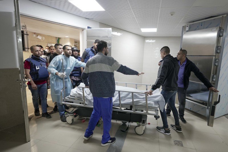 PALESTINIANS-ISRAEL/ Palestinian gunmen carry the body of Al Jazeera reporter Shireen Abu Akleh, who was killed by Israeli army gunfire during an Israeli raid, the Qatar-based news channel said, in Jenin in the Israeli-occupied West Bank May 11, 2022. Israeli military said Abu Akleh may have been shot by Palestinians as they clashed with its troops. REUTERS/Mohamad Torokman