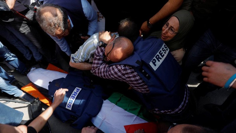 Palestinian gunmen carry the body of Al Jazeera reporter Shireen Abu Akleh, who was killed by Israeli army gunfire during an Israeli raid, the Qatar-based news channel said, in Jenin in the Israeli-occupied West Bank May 11, 2022. Israeli military said Abu Akleh may have been shot by Palestinians as they clashed with its troops. REUTERS/Mohamad Torokman