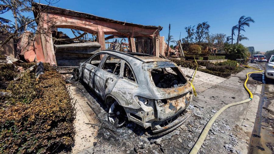 A firefighter sprays water on the remains of a burned-out home after a fast-moving wildfire ripped through an affluent neighborhood in Laguna Niguel, California, U.S., May 12, 2022. REUTERS/Mike Blake