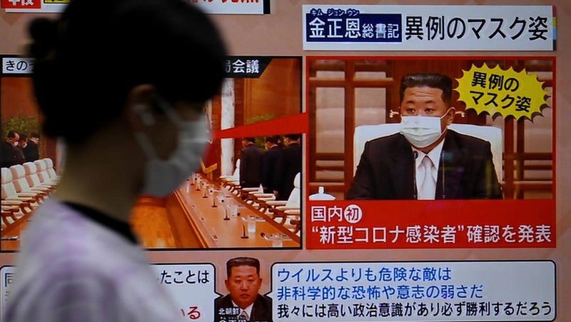 A passerby walks past a screen displaying an image of North Korean leader Kim Jong Un wearing a face mask on a TV news program in Tokyo, Friday, May 13, 2022. North Korea imposed a nationwide lockdown Thursday to control its first acknowledged COVID-19 outbreak after holding for more than two years to a widely doubted claim of a perfect record keeping out the virus that has spread to nearly every place in the world.(AP Photo/Shuji Kajiyama)