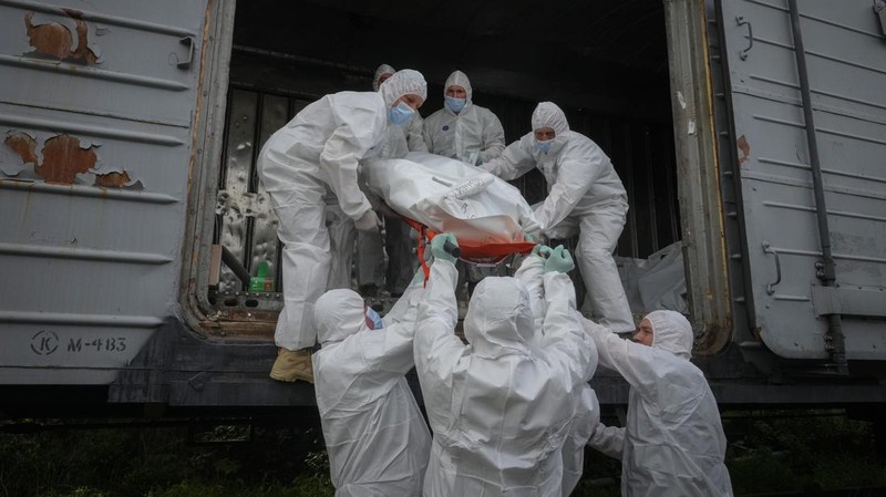 Ukrainian servicemen collect bodies of Russian soldiers to load into a railway refrigerator carriage in Kyiv, Ukraine, Friday, May 13, 2022. (AP Photo/Efrem Lukatsky)