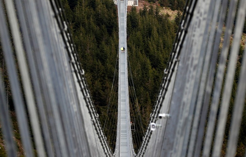 People walk across the newly-built world's longest suspension bridge after its official opening in the mountain resort of Dolni Morava, Czech Republic, May 13, 2022. REUTERS/David W Cerny *** Local Caption *** CAPTION TEST 01