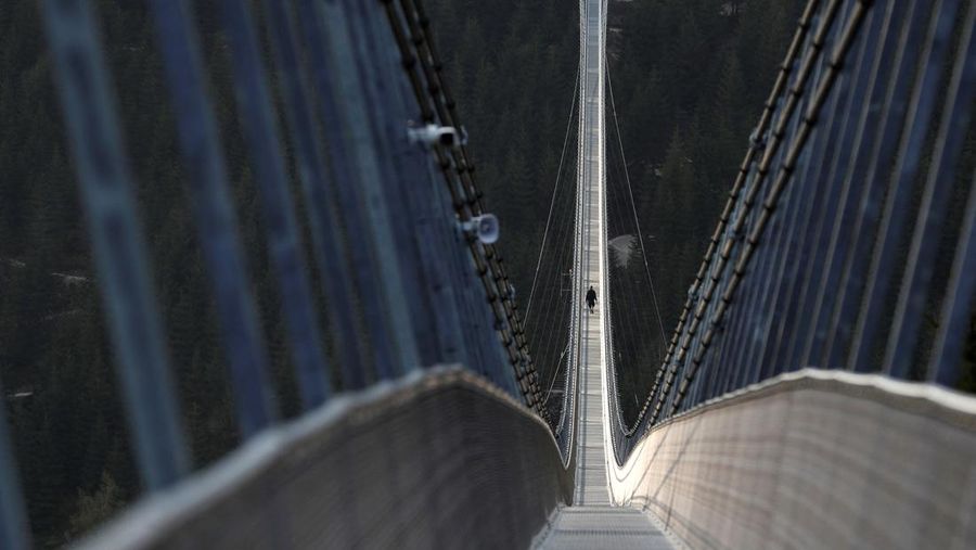 A staff member walks across the newly-built world's longest suspension bridge a day before its official opening in the mountain resort of Dolni Morava, Czech Republic, May 12, 2022. Picture taken May 12, 2022. REUTERS/David W Cerny *** Local Caption *** CAPTION TEST 01