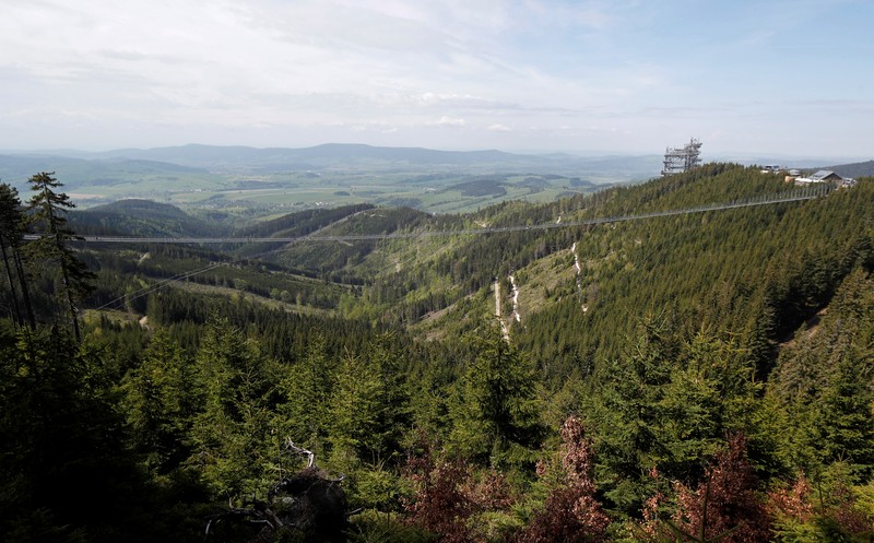 People walk across the newly-built world's longest suspension bridge after its official opening in the mountain resort of Dolni Morava, Czech Republic, May 13, 2022. REUTERS/David W Cerny *** Local Caption *** CAPTION TEST 01