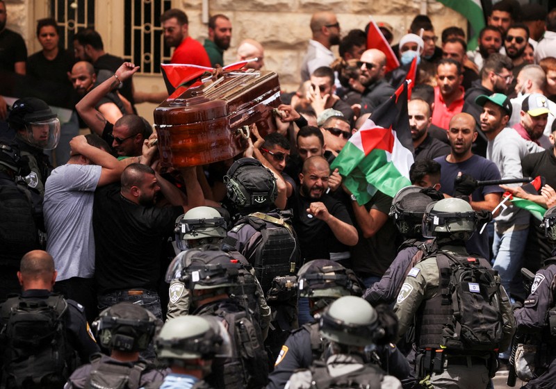 Family and friends carry the coffin of Al Jazeera reporter Shireen Abu Akleh, who was killed during an Israeli raid in Jenin in the occupied West Bank, as clashes erupted with Israeli security forces, during her funeral in Jerusalem, May 13, 2022. REUTERS/Ammar Awad