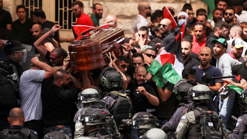 Family and friends carry the coffin of Al Jazeera reporter Shireen Abu Akleh, who was killed during an Israeli raid in Jenin in the occupied West Bank, as clashes erupted with Israeli security forces, during her funeral in Jerusalem, May 13, 2022. REUTERS/Ammar Awad