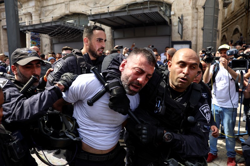 Family and friends carry the coffin of Al Jazeera reporter Shireen Abu Akleh, who was killed during an Israeli raid in Jenin in the occupied West Bank, as clashes erupted with Israeli security forces, during her funeral in Jerusalem, May 13, 2022. REUTERS/Ammar Awad