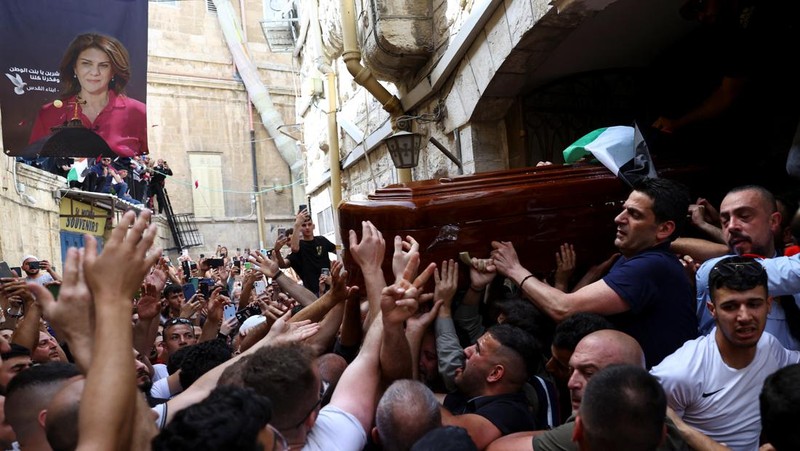 Family and friends carry the coffin of Al Jazeera reporter Shireen Abu Akleh, who was killed during an Israeli raid in Jenin in the occupied West Bank, as clashes erupted with Israeli security forces, during her funeral in Jerusalem, May 13, 2022. REUTERS/Ammar Awad