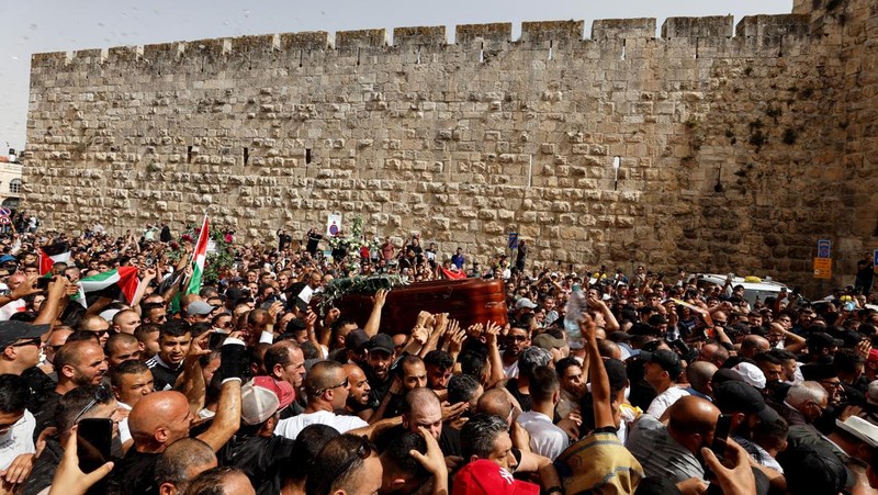 Family and friends carry the coffin of Al Jazeera reporter Shireen Abu Akleh, who was killed during an Israeli raid in Jenin in the occupied West Bank, as clashes erupted with Israeli security forces, during her funeral in Jerusalem, May 13, 2022. REUTERS/Ammar Awad