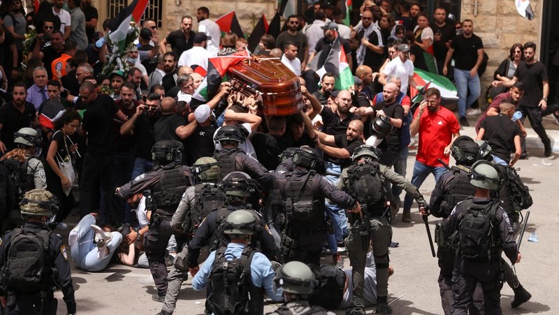 Family and friends carry the coffin of Al Jazeera reporter Shireen Abu Akleh, who was killed during an Israeli raid in Jenin in the occupied West Bank, as clashes erupted with Israeli security forces, during her funeral in Jerusalem, May 13, 2022. REUTERS/Ammar Awad