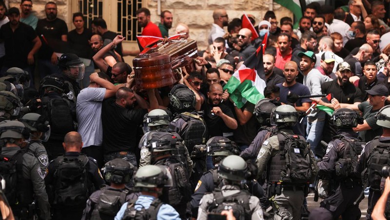 Family and friends carry the coffin of Al Jazeera reporter Shireen Abu Akleh, who was killed during an Israeli raid in Jenin in the occupied West Bank, as clashes erupted with Israeli security forces, during her funeral in Jerusalem, May 13, 2022. REUTERS/Ammar Awad