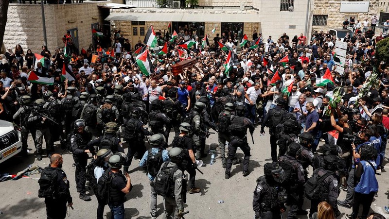 Family and friends carry the coffin of Al Jazeera reporter Shireen Abu Akleh, who was killed during an Israeli raid in Jenin in the occupied West Bank, as clashes erupted with Israeli security forces, during her funeral in Jerusalem, May 13, 2022. REUTERS/Ammar Awad