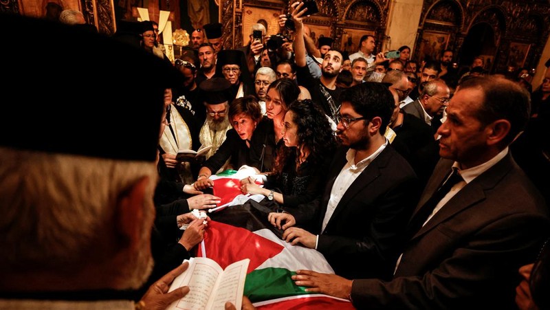 Family and friends carry the coffin of Al Jazeera reporter Shireen Abu Akleh, who was killed during an Israeli raid in Jenin in the occupied West Bank, as clashes erupted with Israeli security forces, during her funeral in Jerusalem, May 13, 2022. REUTERS/Ammar Awad
