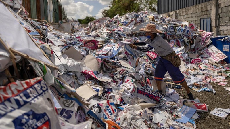 A worker sorts through piles of campaign posters left over from the national election at a recylcing facility in Marikina City, Philippines, May 12, 2022. REUTERS/Eloisa Lopez