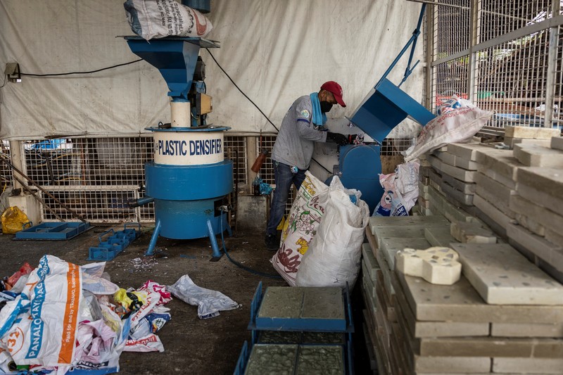 A worker sorts through piles of campaign posters left over from the national election at a recylcing facility in Marikina City, Philippines, May 12, 2022. REUTERS/Eloisa Lopez