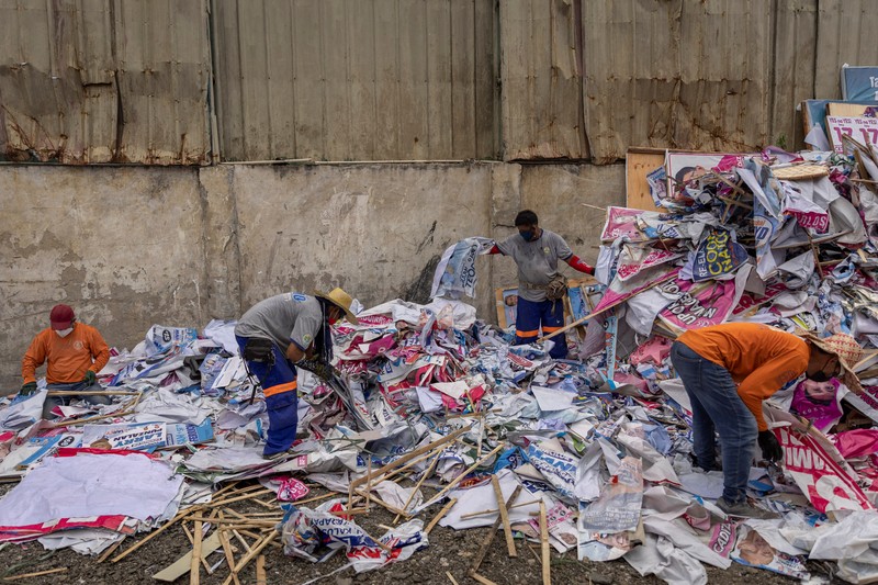 A worker sorts through piles of campaign posters left over from the national election at a recylcing facility in Marikina City, Philippines, May 12, 2022. REUTERS/Eloisa Lopez