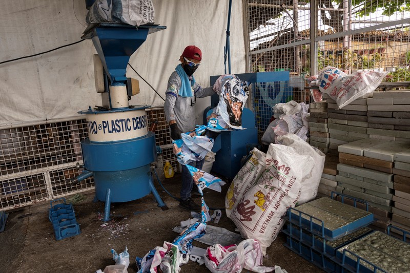A worker sorts through piles of campaign posters left over from the national election at a recylcing facility in Marikina City, Philippines, May 12, 2022. REUTERS/Eloisa Lopez