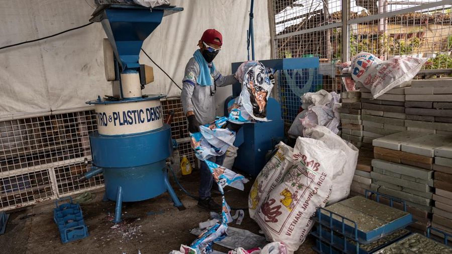 A worker sorts through piles of campaign posters left over from the national election at a recylcing facility in Marikina City, Philippines, May 12, 2022. REUTERS/Eloisa Lopez