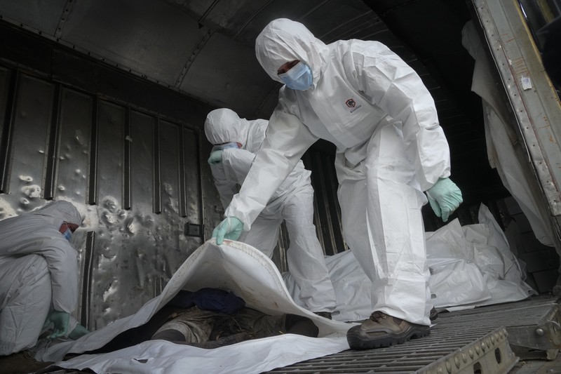 Russia Ukraine War Ukrainian servicemen collect bodies of Russian soldiers to load into a railway refrigerator carriage in Kyiv, Ukraine, Friday, May 13, 2022. (AP Photo/Efrem Lukatsky)