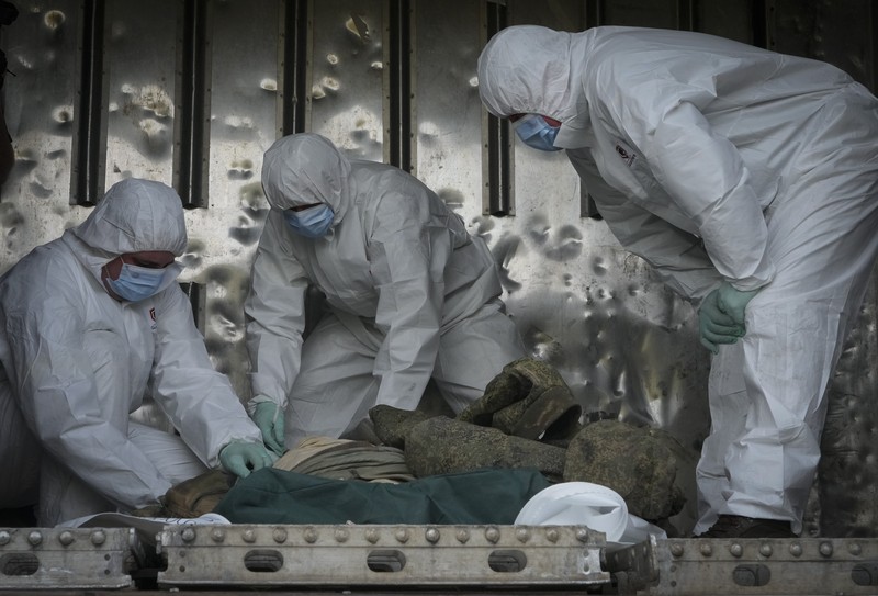 Russia Ukraine War Ukrainian servicemen collect bodies of Russian soldiers to load into a railway refrigerator carriage in Kyiv, Ukraine, Friday, May 13, 2022. (AP Photo/Efrem Lukatsky)