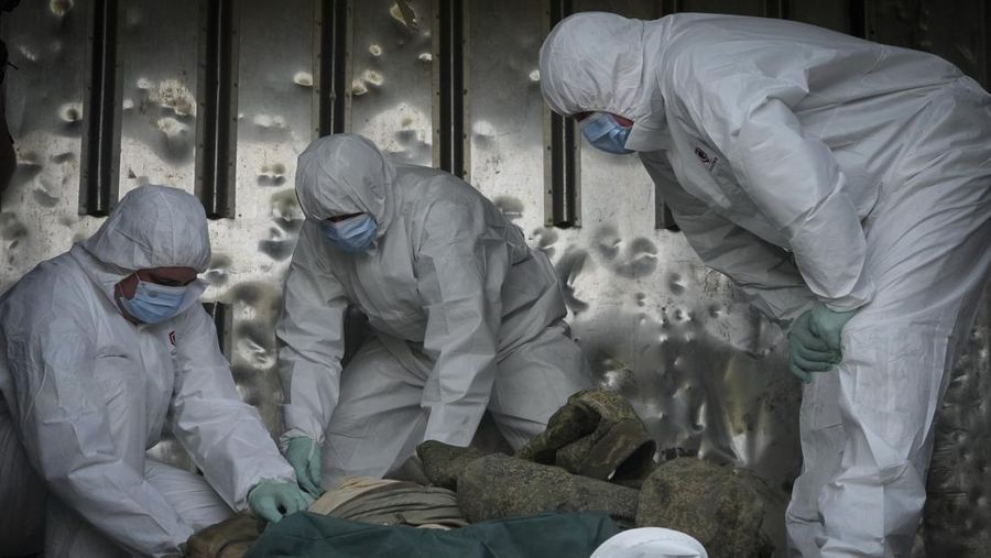 Ukrainian servicemen collect bodies of Russian soldiers to load into a railway refrigerator carriage in Kyiv, Ukraine, Friday, May 13, 2022. (AP Photo/Efrem Lukatsky)
