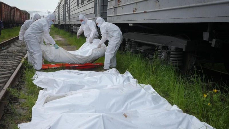 Ukrainian servicemen collect bodies of Russian soldiers to load into a railway refrigerator carriage in Kyiv, Ukraine, Friday, May 13, 2022. (AP Photo/Efrem Lukatsky)