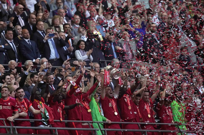 Liverpool players hold the trophy and celebrate after winning the English FA Cup final soccer match between Chelsea and Liverpool, at Wembley stadium, in London, Saturday, May 14, 2022. (AP Photo/Kirsty Wigglesworth)