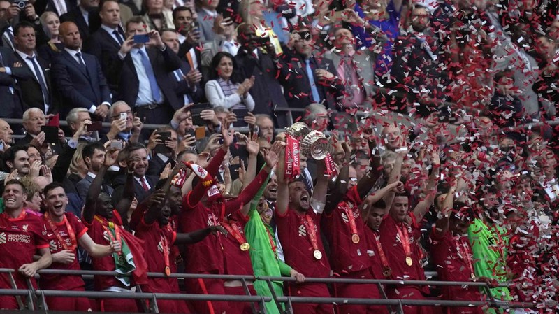 Liverpool players hold the trophy and celebrate after winning the English FA Cup final soccer match between Chelsea and Liverpool, at Wembley stadium, in London, Saturday, May 14, 2022. (AP Photo/Kirsty Wigglesworth)