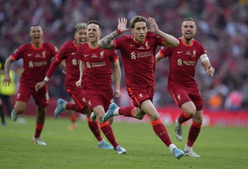 Liverpool players hold the trophy and celebrate after winning the English FA Cup final soccer match between Chelsea and Liverpool, at Wembley stadium, in London, Saturday, May 14, 2022. (AP Photo/Kirsty Wigglesworth)