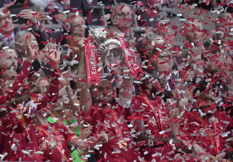 Liverpool players hold the trophy and celebrate after winning the English FA Cup final soccer match between Chelsea and Liverpool, at Wembley stadium, in London, Saturday, May 14, 2022. (AP Photo/Kirsty Wigglesworth)